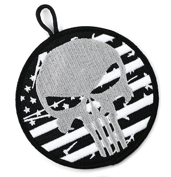 Black, white, and silver circular embroidered patch with button loop and abstract skull and textured american flag